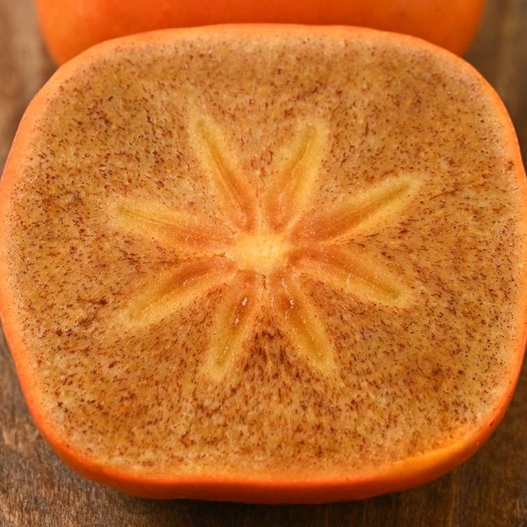 嘉黒を横に切った断面。星のような模様と、果肉に散る細かな黒い粒